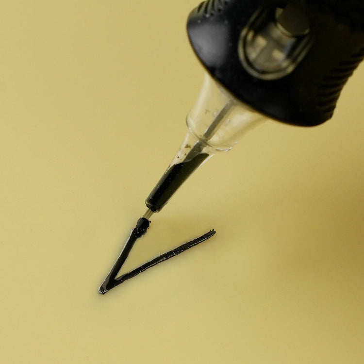 Close-up of a tattoo needle drawing a black ink line on synthetic skin – ideal for beginners practicing with a tattoo starter kit.