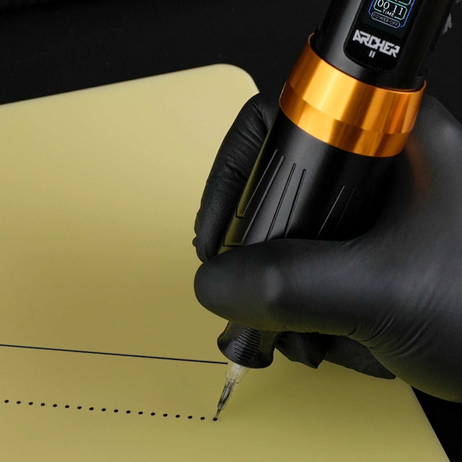 Tattoo artist using the Dragoart Archer II wireless tattoo pen on practice skin to test needle frequency with consistent dot work and a straight line